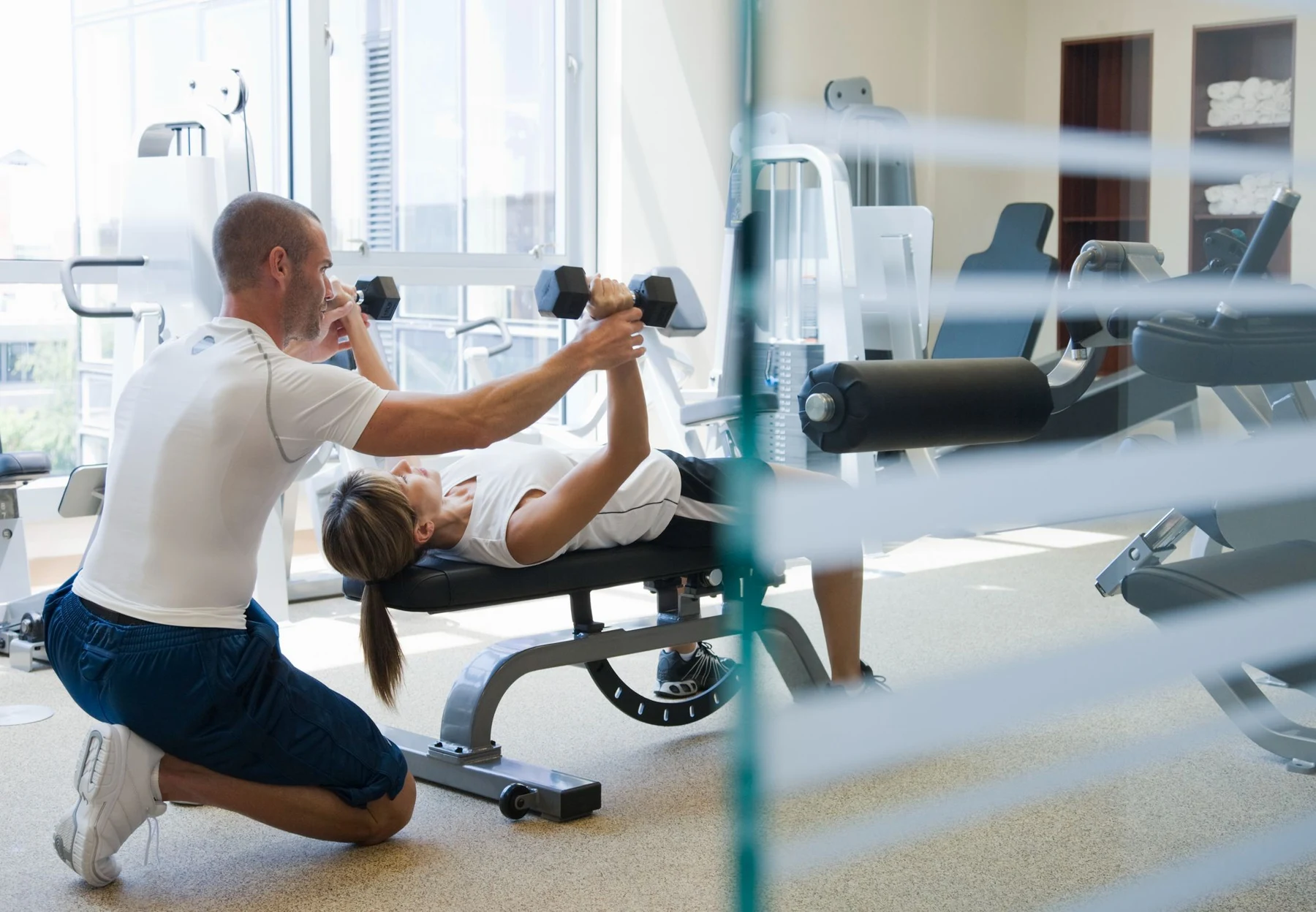 Personal trainer guiding an active older adult