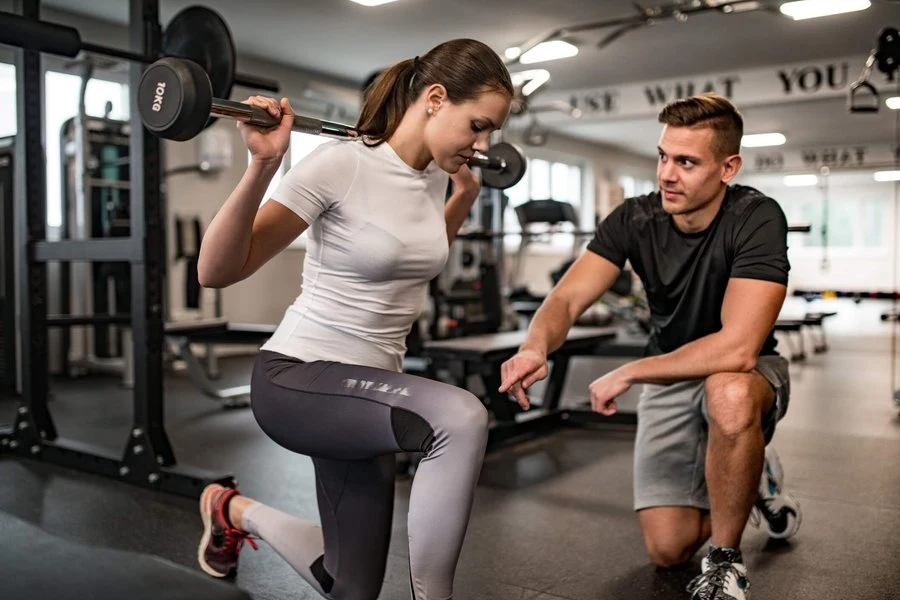 A coach guiding an individual strength training session